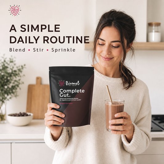 Woman holding Biomel Complete Gut powder and a Belgian chocolate smoothie.